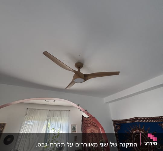מאוורר תקרה בחדר עם קישוטים וצמחים